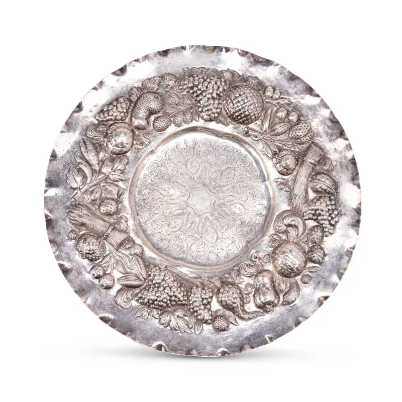A Northern European Silver Charger early 19th Century, of shaped circular form, the rim repoussé decorated with fruit and grain