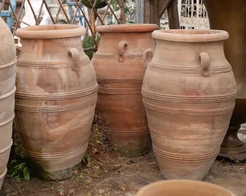 A group of three large North African terracotta storage jars The jars with three lug handles and ring turned decoration to the inverted baluster form bodies App