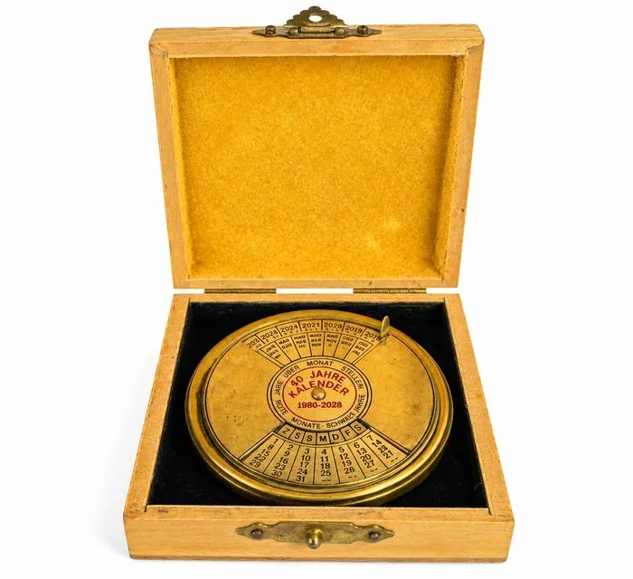 coffret « 50 Jahre Kalender », Ancien calendrier perpétuel rotatif, Instrument de bureau - Measuring instrument - Brass, Wood - 1980
