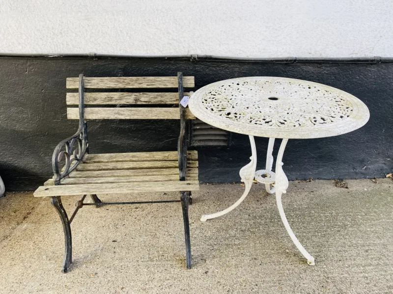 Two items to include a weathered painted cast iron garden chair with wooden slatted seat and backrest (61cms wide x 53.5cms deep x 70cms high)
