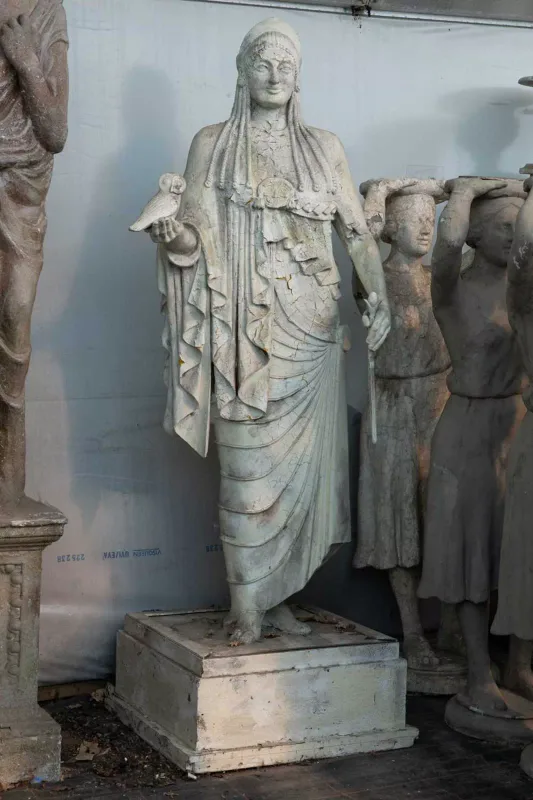 A statue after the antique depicting Kore or Athena The female sculpture holding a wand and an owl, with braids in her hair and wearing period costume