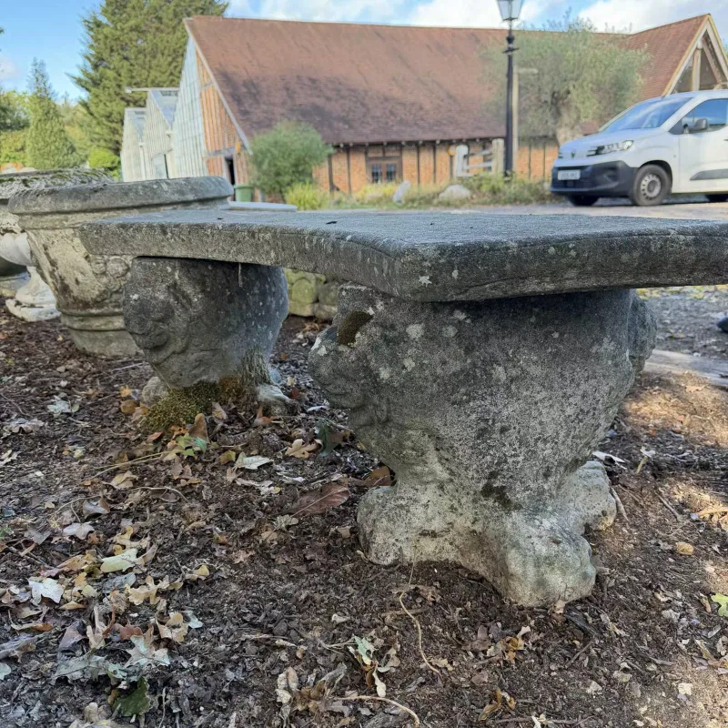 A small curved garden bench The cast reconstituted stone bench with lion decorated supports