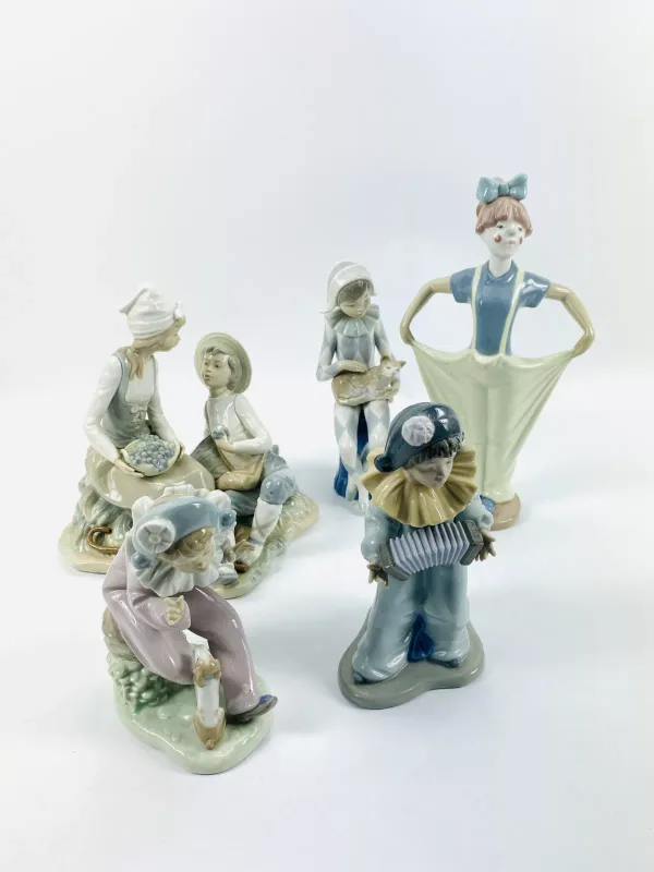 A collection of five Nao porcelain figurines to include a girl and a boy eating grapes (22.75cms wide x 20cms deep x 23cms high)