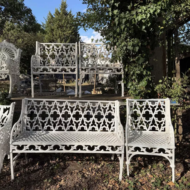 A suite of Georgian style garden furniture The cast white painted aluminium Gothic revival patterned bench together with three matching chairs