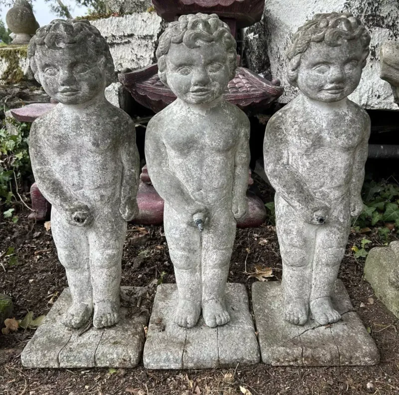 A group of three fountains in the form of urinating boys The cast reconstituted stone sculptures each of similar form and on a square base