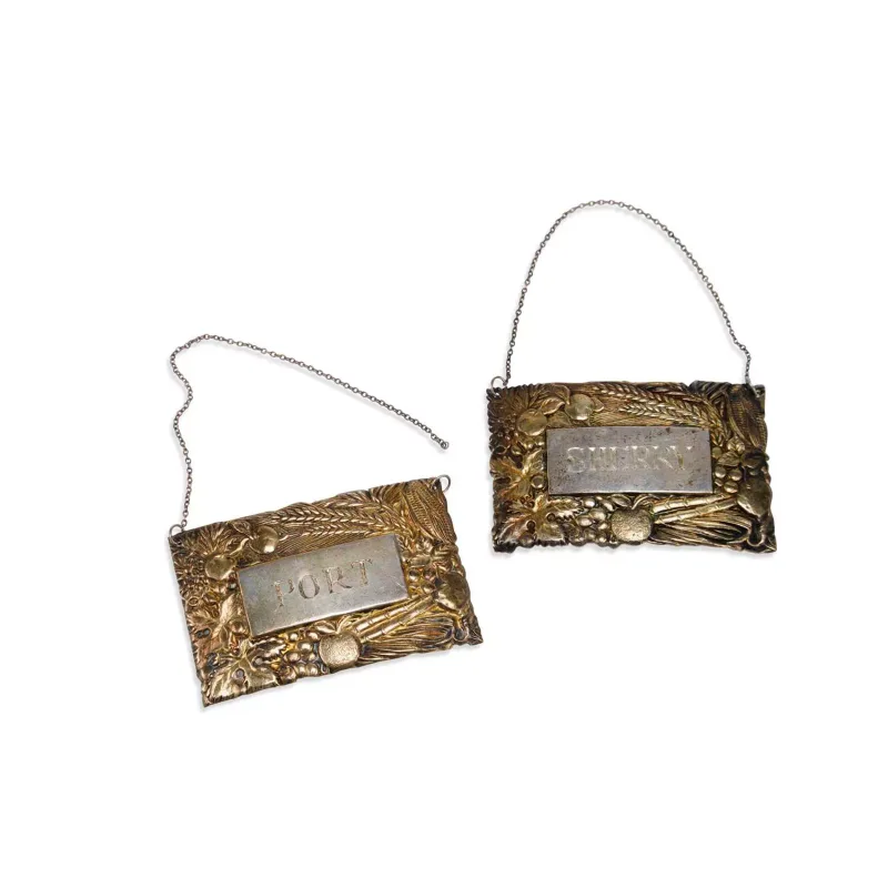 A Pair Of Elizabeth II Parcel-Gilt Silver Wine Labels by Stuart Devlin, London 1985 and 1986, of rectangular form, each chased with fruiting vine