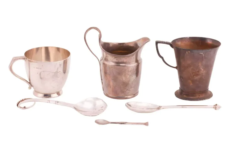 A collection of silver items, comprising a cream jug by Walter Brind, London 1815, with a reeded handle and shaped spout