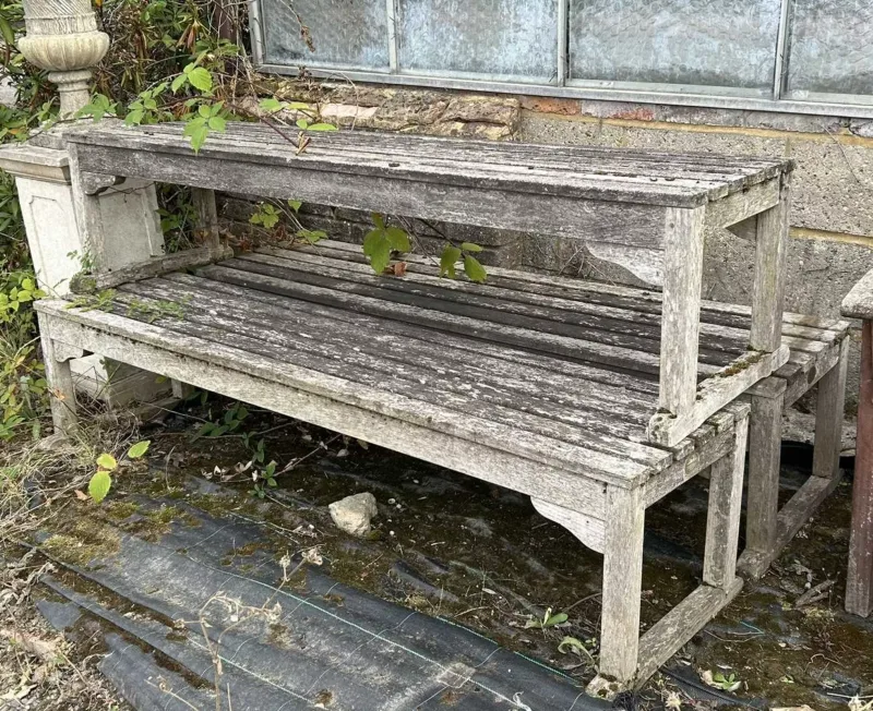 A set of three teak garden benches The benches with slatted seats
