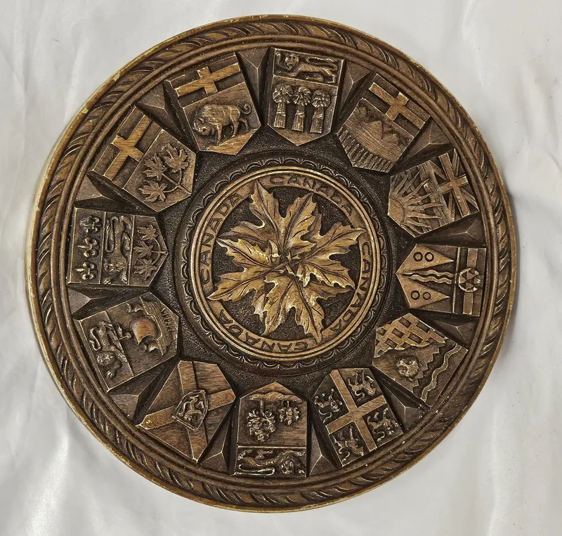 Circular Canadian Wall Plaque with carved maple centre surrounded by coats of arms of Canada's provinces in the style of Carl Rothanner approx.