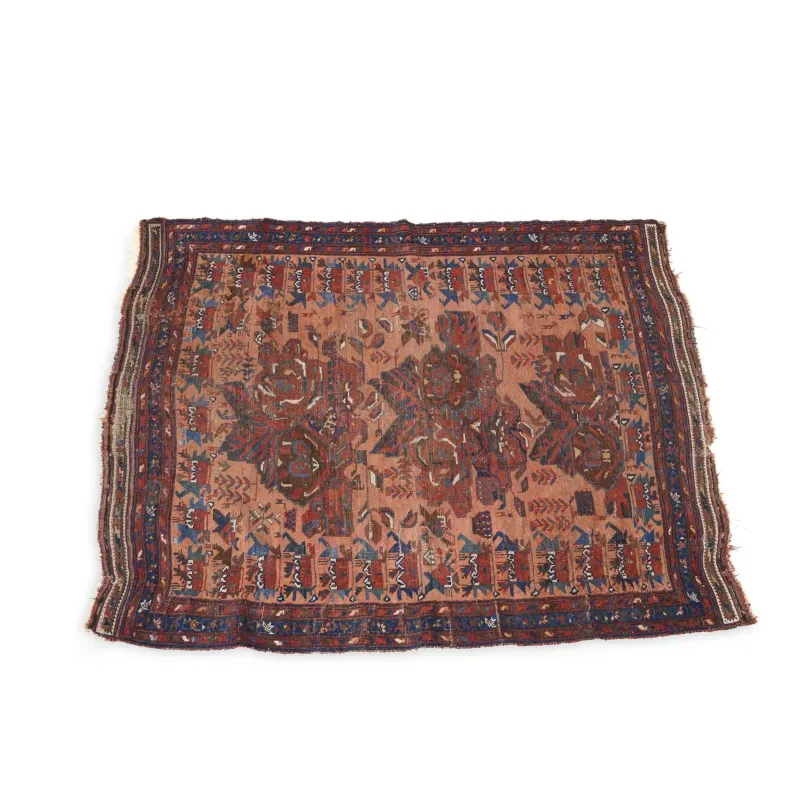 An Antique West Persian Rug the terracotta field worked with bold stylised floral and geometric motifs in indigo, madder and ivory