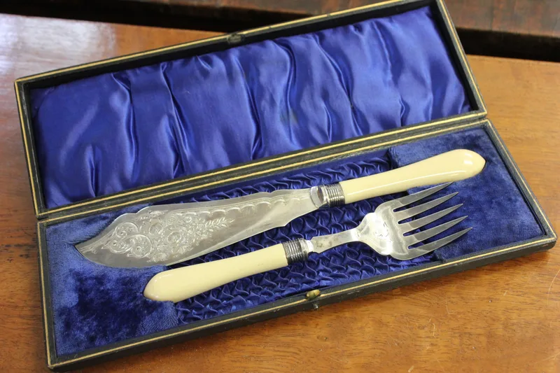 A pair of silver-plated and bone-handled fish servers, with silver ferrules Sheffield 1902, in lined case