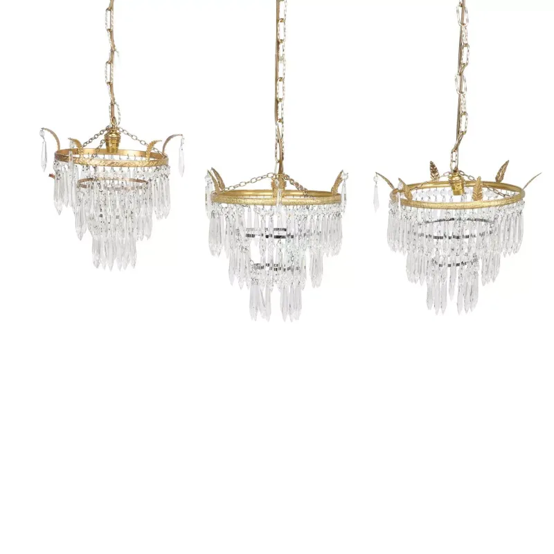 A Pair Of Gilt Metal And Glass Waterfall Chandeliers And A Similar Single each with a leaf cast corona hung with graduated faceted icicle drops