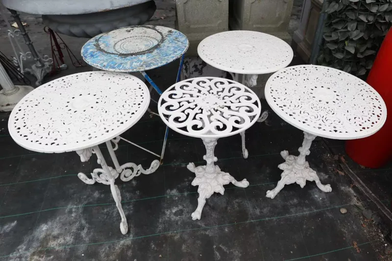 A group of five circular garden tables Each table with pierced tops, four with cast iron bases