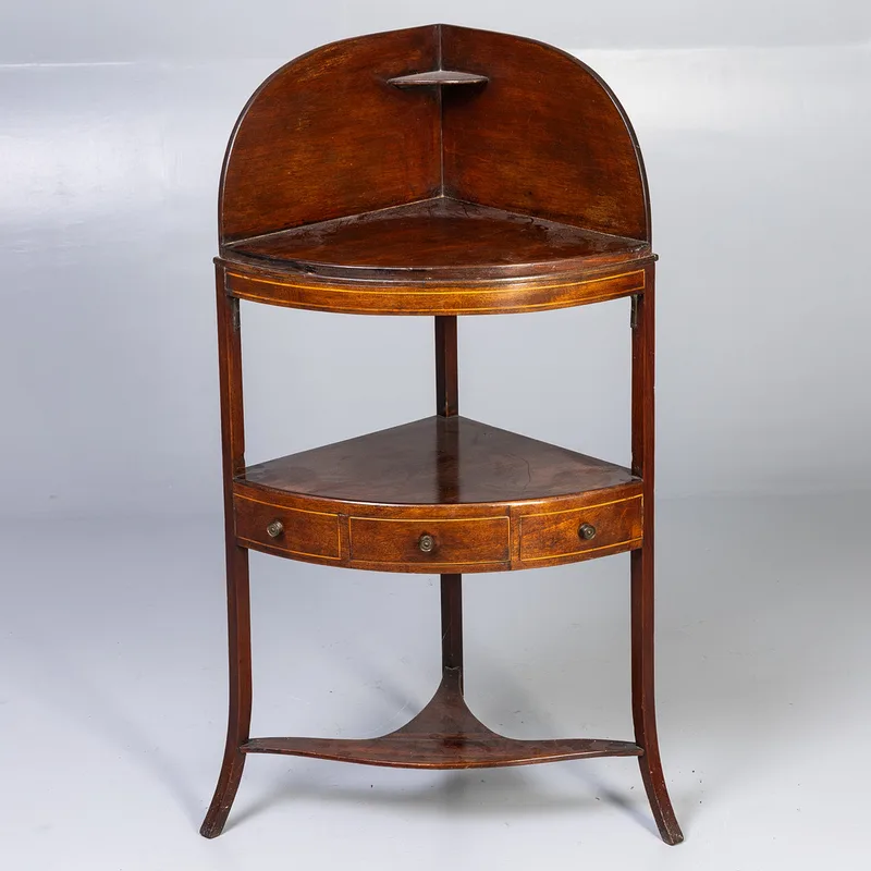 A 19th century mahogany corner washstand, having raised back, middle tier with central drawer flanked by faux drawer fronts, base undertier stretcher