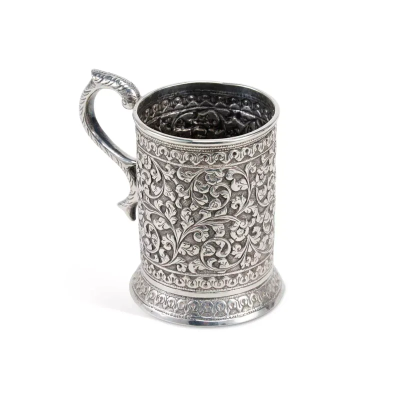 An Indian Silver Tankard apparently unmarked, chased with repeating foliate scrolls, with a shaped scroll handle.