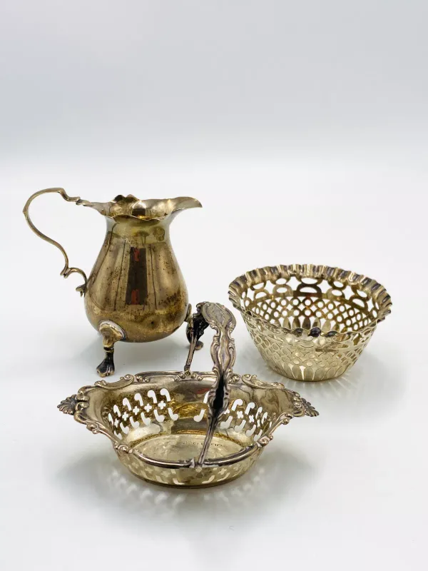 A silver milk jug; together with two pierced silver dishes