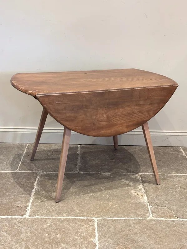 An Ercol Blonde drop leaf table, raised on four outswept legs,
