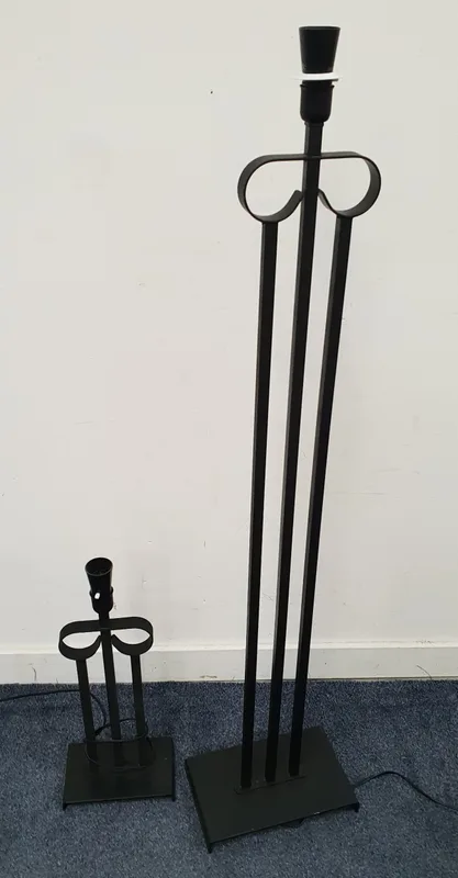 Pair Of Contemporary Lamps both of black painted cast metal and comprising three vertical rods with integrated fitting at the top, both on rectangular bases