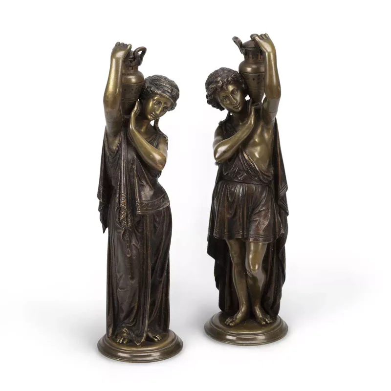 A Pair Of Bronze Figures Of Classical Water Carriers 19th Century, each modelled standing with both arms raised to steady a covered amphora upon the shoulder