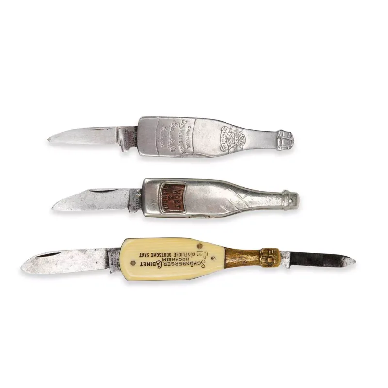 Three Novelty Wine Bottle Pen Knives Early 20th Century two champagne themed by John Watts, Sheffield, the other by Trafalgar Works