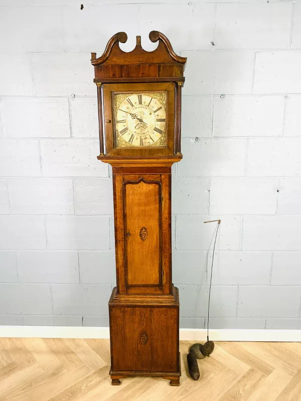 A late 18th century oak cased longcase clock with mahogany and inlaid decoration, the silvered square dial