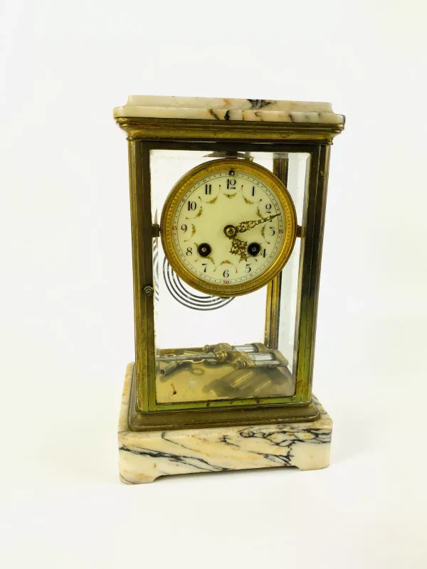 A large early 20th century French marble eight day mantle clock with four bevelled glass panels, an enamelled decorative dial and striking on a gong