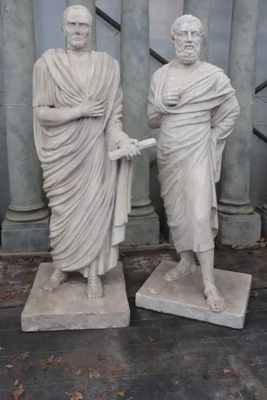 A pair of sculptures depicting Roman senators The senators both wearing togas, one holding a scroll