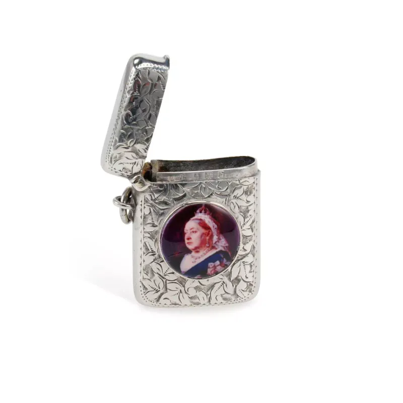 An Edwardian Silver And Enamel Vesta Case by Henry Williamson Ltd., Birmingham 1901, of curved rectangular form with a hinged cover, foliate engraved