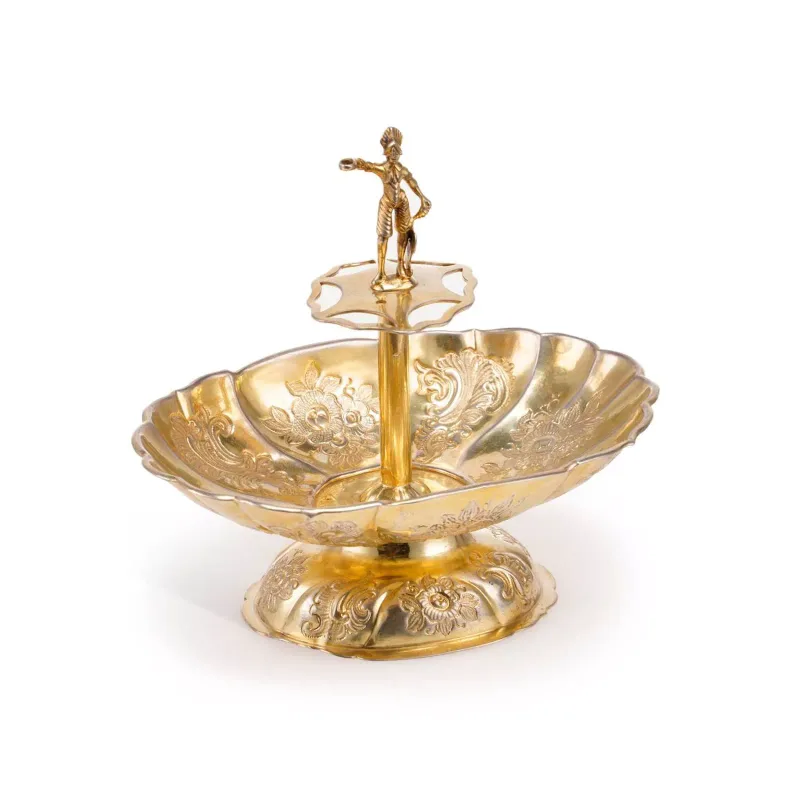 A Continental Silver-Gilt Figural Sweetmeat Dish possibly Hanau, late 19th Century, of fluted oval form, embossed with foliate scrolls