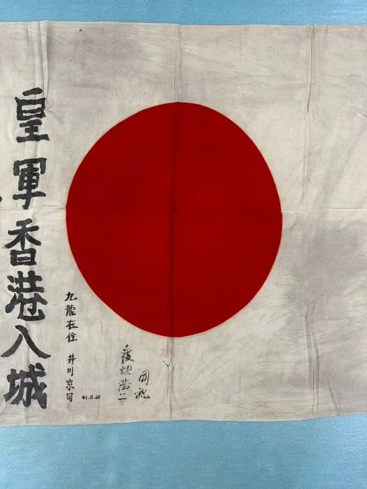 Japan - Flag - December 28, 1941. Japanese residents greeted the Japanese army with a celebratory flag upon their