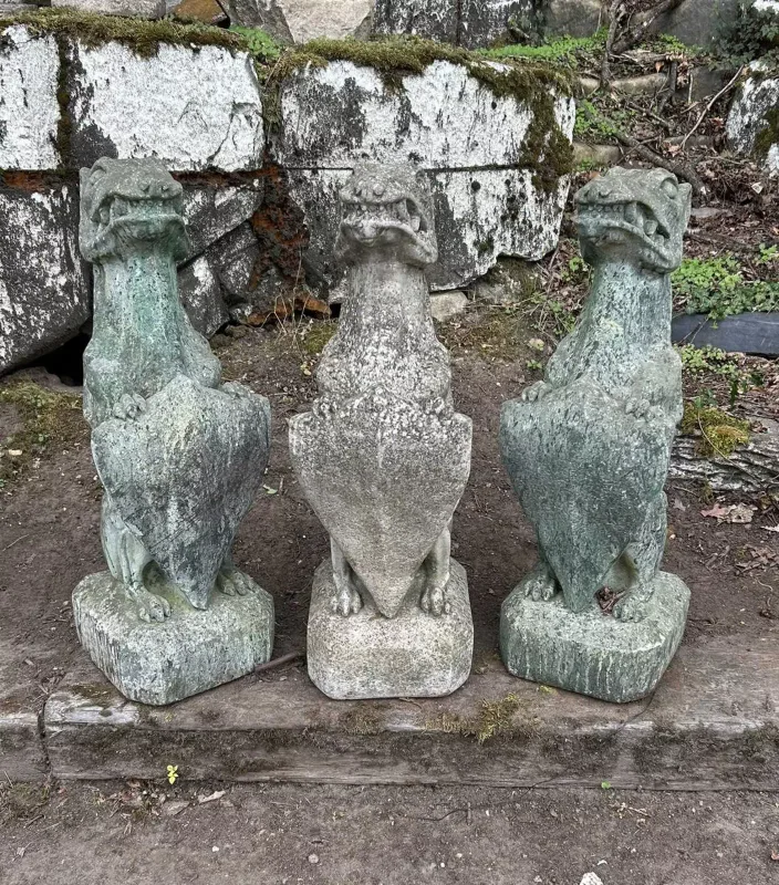 A group of three grotesque armorial hounds The three cast reconstituted stone hounds each seated on its haunches and supporting a shield