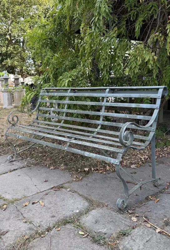 A wrought iron garden bench The green painted wrought iron bench with scrolling ends