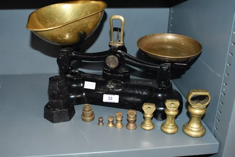 A mid 20th-century metal Librasco cast iron and brass balance scales, accompanied by three sets of graduated weights, marked, (1 scale and 3 sets of weights)