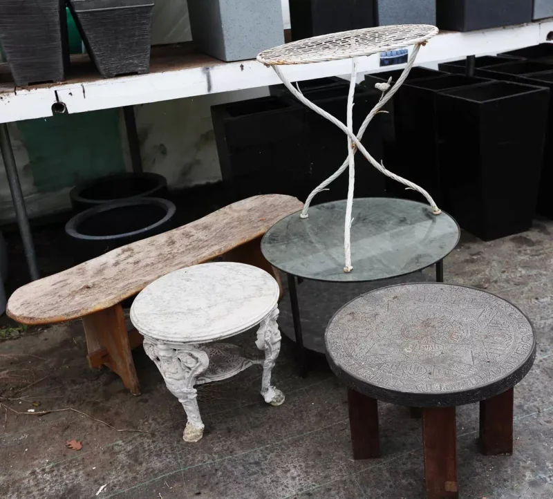 A group of four conservatory or garden tables together with an elm bench One table in the Victorian style with a marble top