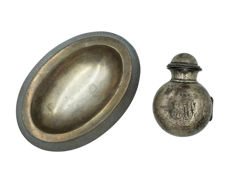 A silver ashtray and smelling salts bottle