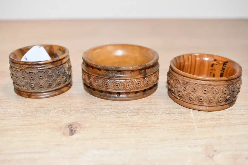 Three vintage Jerusalem carved coquilla nut napkin ring holders, each of flared form and decorated with rows of small circular bullseye-style dot motifs