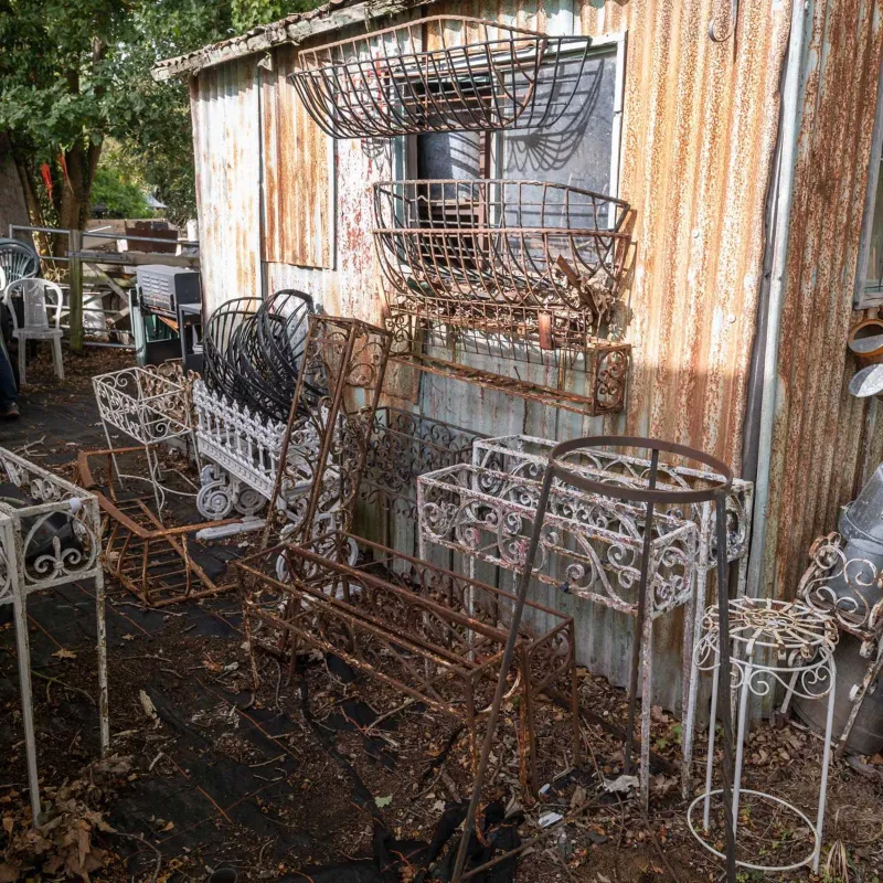 A group of twenty four various wrought iron plant stands and wall brackets Each of varying styles and sizes