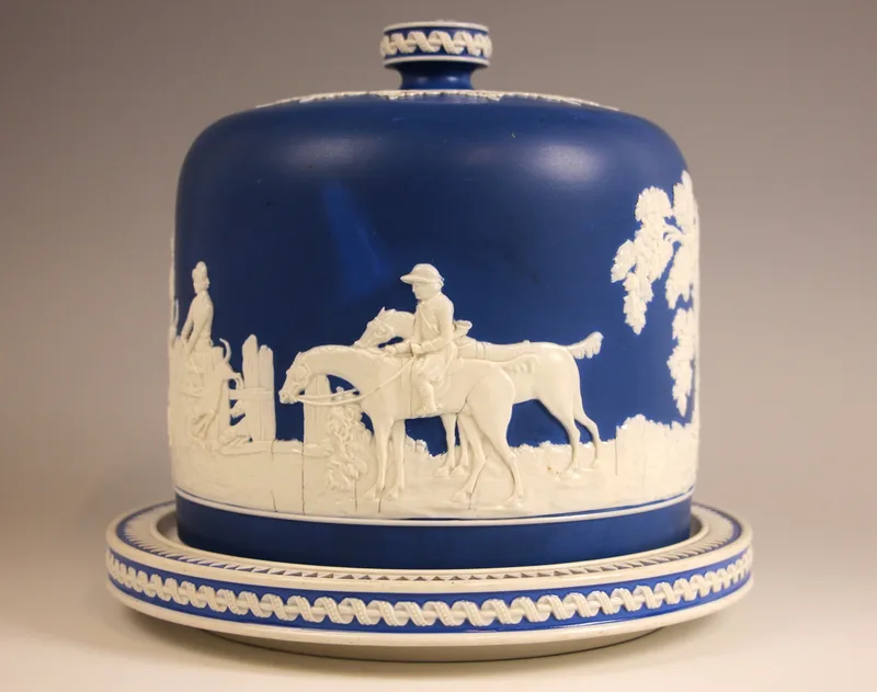 A Copeland cheese dome and stand, mid 19th century, the blue ground dome applied with a continuous sprig moulded hunting scene, rivet repaired