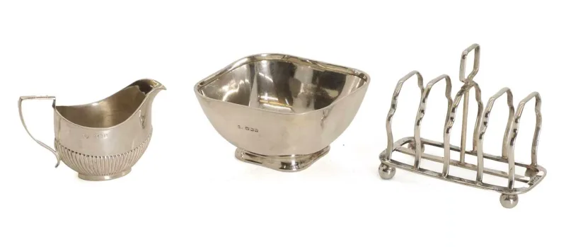 A silver bowl, a toast rack and a small cream jug, various dates, each of plain form