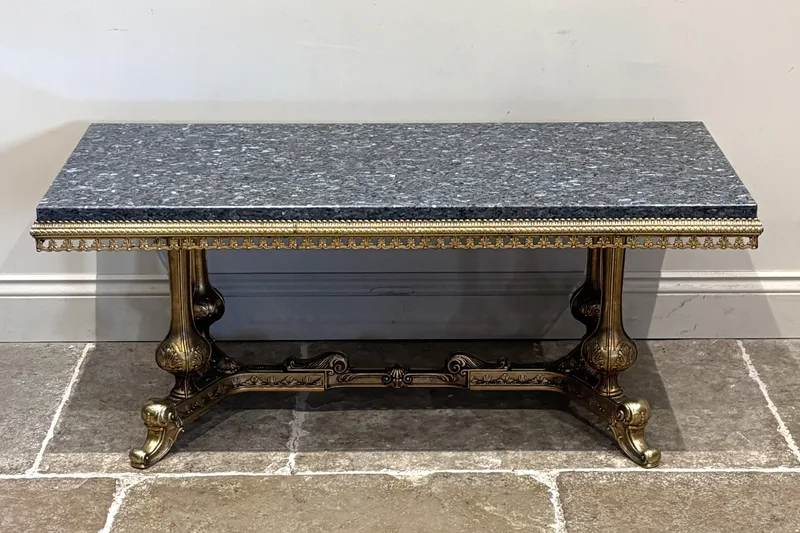 An Italian marble topped and gilt metal coffee table, the grey rectangular marble top raised on an elaborate gilt painted base,