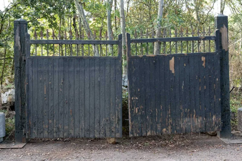 A pair of entrance gates The painted pine driveway gates with a run of cast iron 'spear top' finials