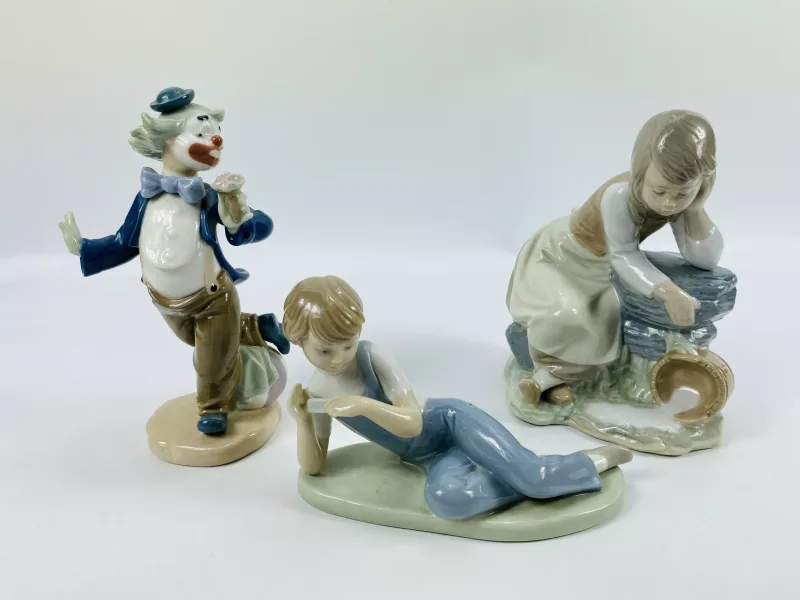 A collection of three Nao porcelain figurines to include 'Girl With Spilled Milk', model No.0137 (16cms wide x 13cms deep x 20cms high)