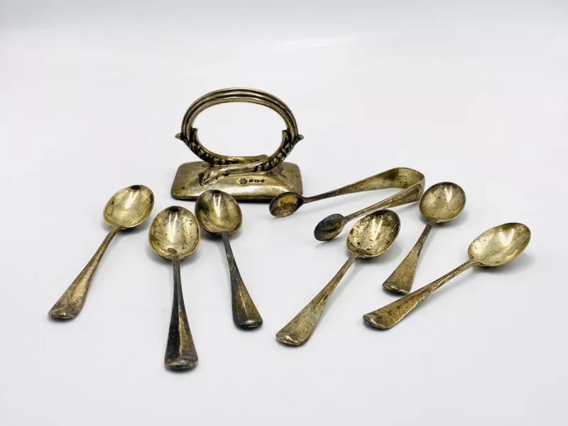 A set of six silver coffee spoons and tongs together with a silver handle