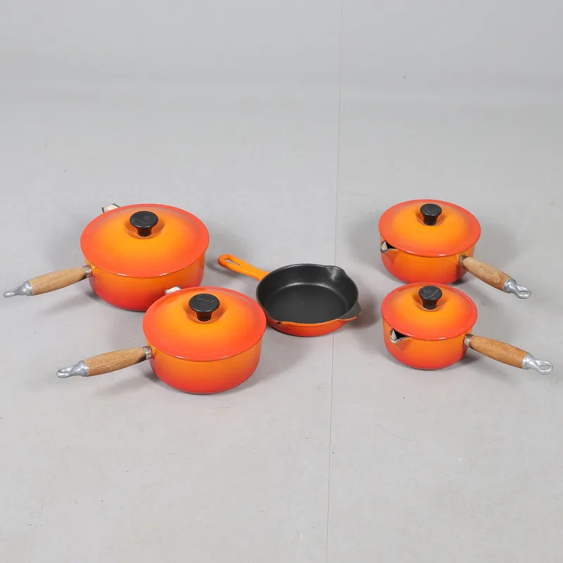 A Graduated Set of Four Lidded le Creuset Saucepans, and a Similar French Skillet