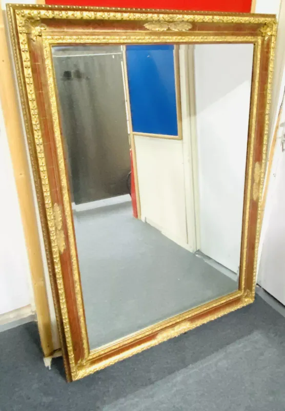 A large antique style gilt wall mirror with a bevelled plate glass