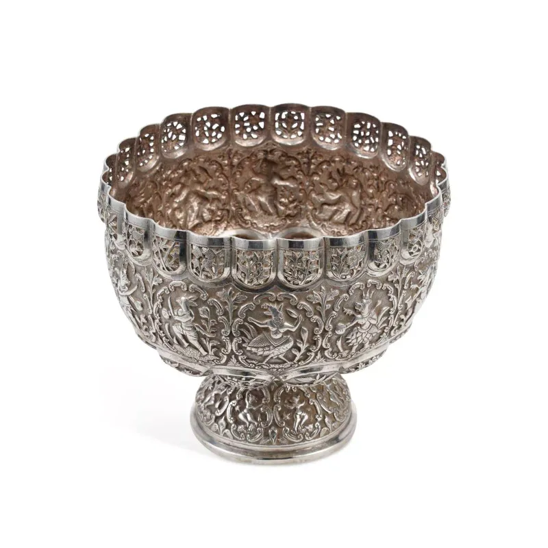 A South Asian Silver Pedestal Bowl apparently unmarked, of circular form, embossed with panels of zoomorphic deities holding weapons aloft