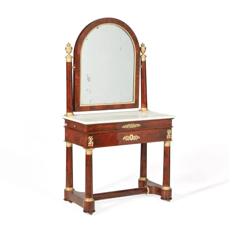 An Empire Style Mahogany Dressing Table 19th Century, with gilt metal mounts throughout, the arched mirror above a marble top and a frieze drawer
