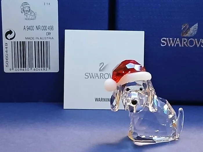 Swarovski - Verena Castelein - Figure - Weihnachtshund Hund mit Santas Mütze mit Box und Etikette 5060449 - Crystal