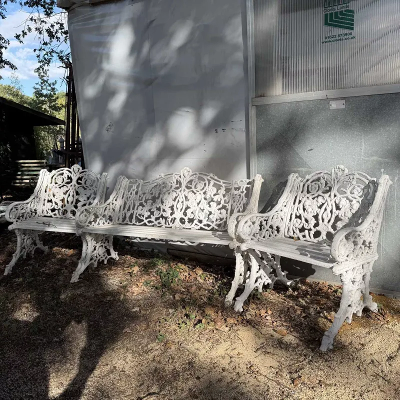 A Victorian style garden bench and two matching chairs The white painted cast aluminium bench and chairs each with foliate scroll decoration to the back and sid