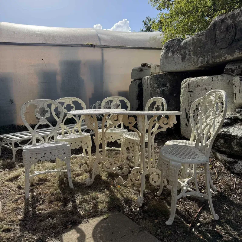 A group of garden furniture The cream painted cast aluminium tables centrally decorated with a profile of a roman soldier within the pierced tops